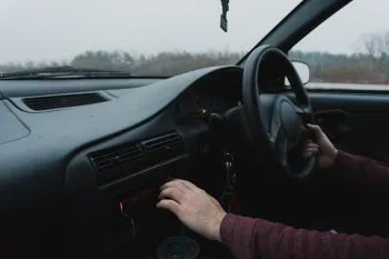 Photo of person driving while playing with radio